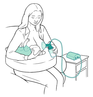 Mother sitting to breastfeed baby on one breast and pump milk on other breast.